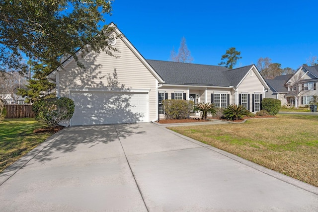 view of front facade with a front yard, concrete driveway, fence, and a garage