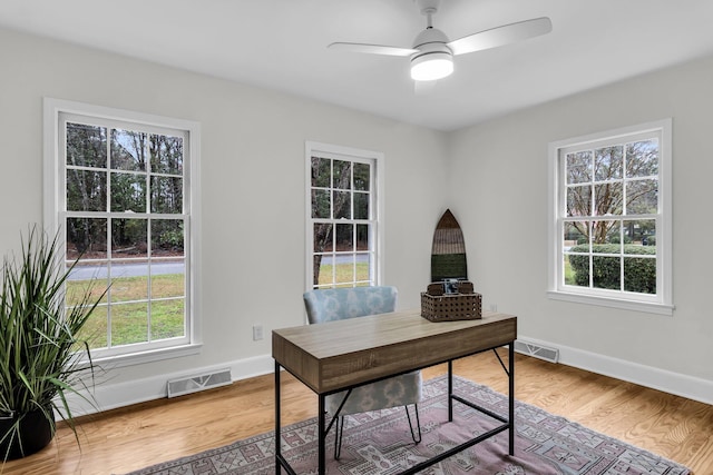 home office with visible vents, baseboards, and wood finished floors