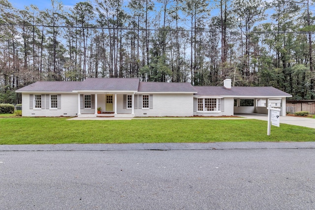 single story home featuring a front lawn, a carport, concrete driveway, a chimney, and crawl space