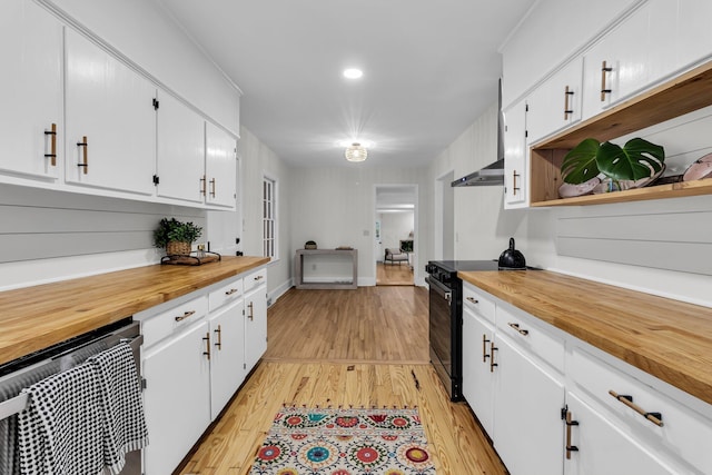 kitchen with electric range, butcher block counters, light wood-style floors, and open shelves