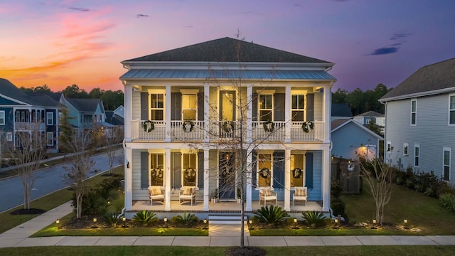 view of front facade featuring french doors, a balcony, and a porch