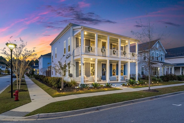 greek revival house with a balcony and covered porch