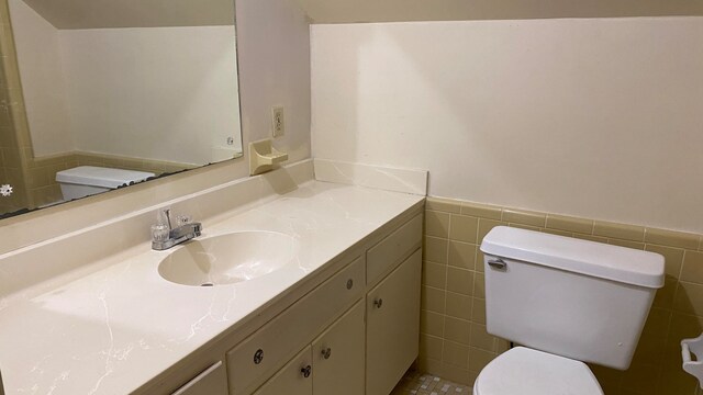 bathroom featuring vanity, tile walls, toilet, and tile patterned flooring