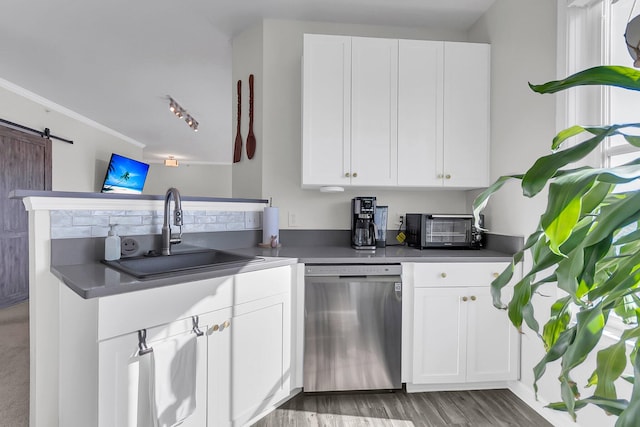 kitchen featuring dishwasher, a barn door, white cabinetry, and sink