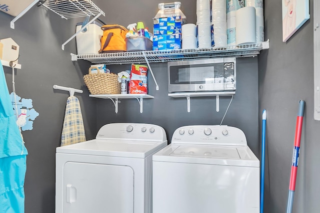 clothes washing area with washing machine and dryer