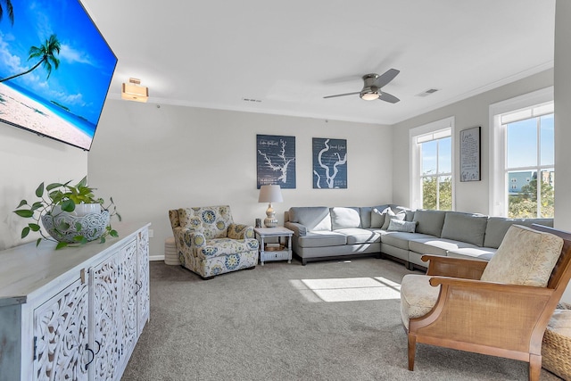 carpeted living room featuring ceiling fan and ornamental molding