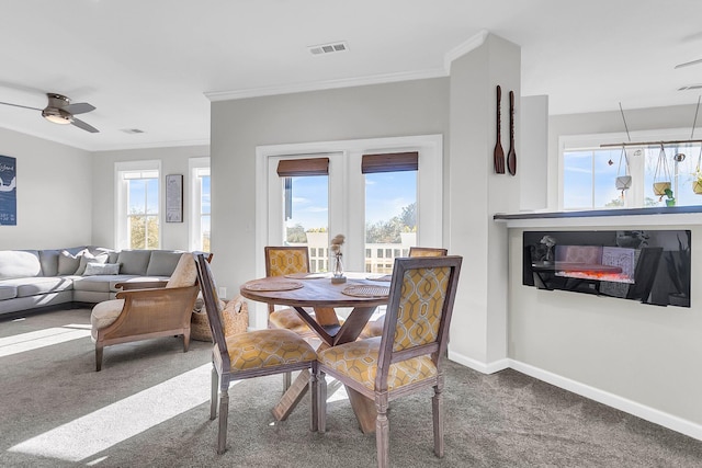 dining space featuring carpet flooring, ceiling fan, and crown molding