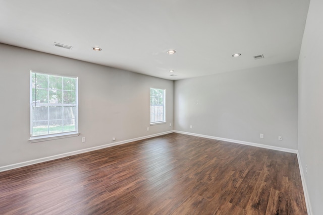 spare room with baseboards, recessed lighting, dark wood finished floors, and visible vents