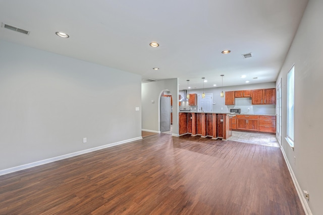 unfurnished living room with recessed lighting, baseboards, visible vents, and dark wood finished floors