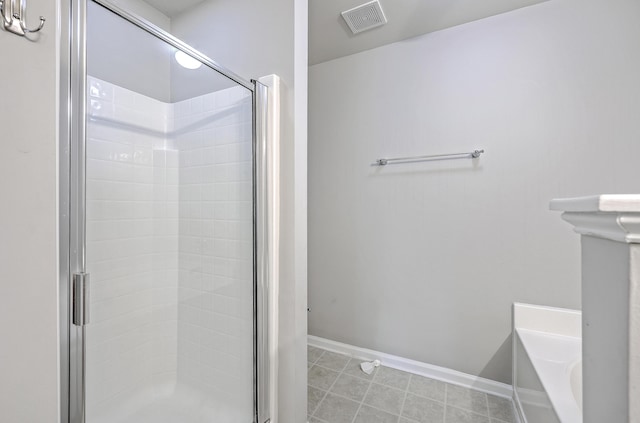 bathroom featuring a shower stall, baseboards, visible vents, and a tub