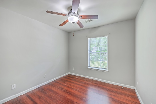 empty room with ceiling fan, baseboards, visible vents, and wood finished floors