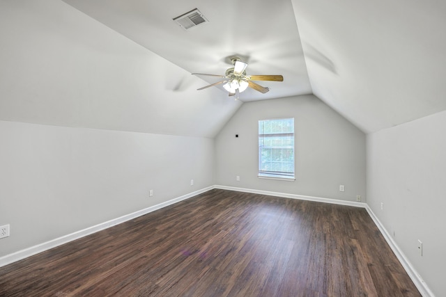 bonus room featuring a ceiling fan, visible vents, baseboards, dark wood-style flooring, and vaulted ceiling