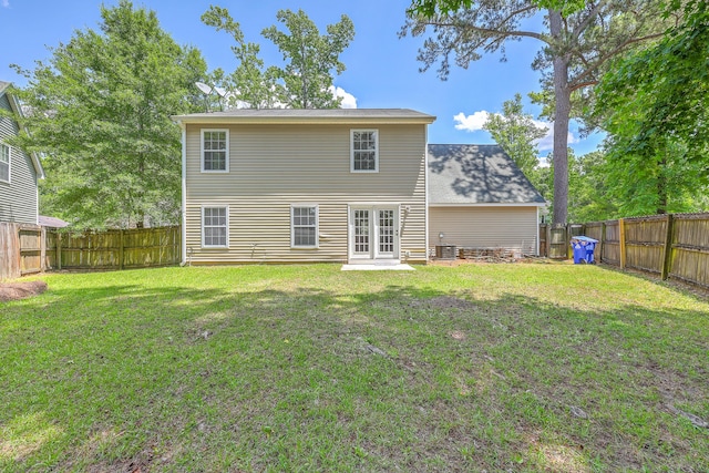 back of property with a yard, a fenced backyard, and central air condition unit