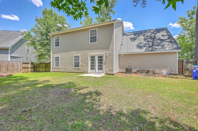 rear view of property with french doors, a lawn, and a fenced backyard