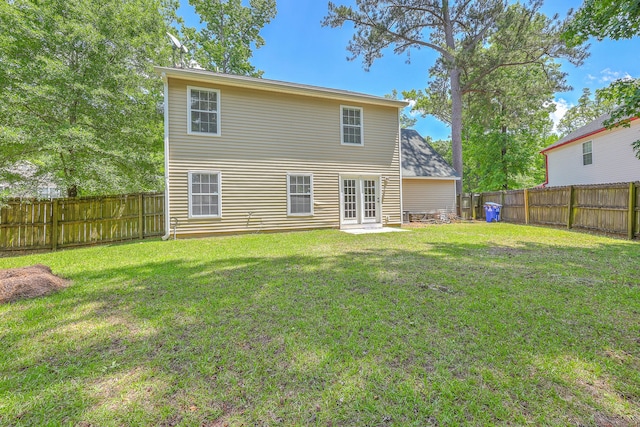 back of house with a lawn and a fenced backyard