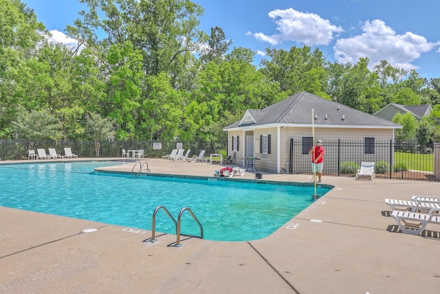 community pool featuring fence and a patio area