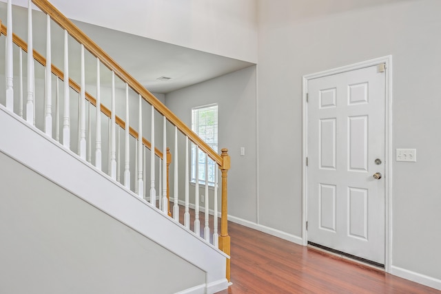 foyer featuring stairway, baseboards, and wood finished floors