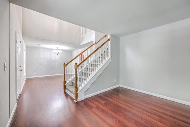 interior space featuring stairway, a chandelier, baseboards, and wood finished floors