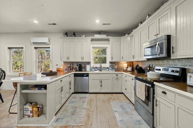 kitchen featuring open shelves, appliances with stainless steel finishes, white cabinetry, and decorative backsplash