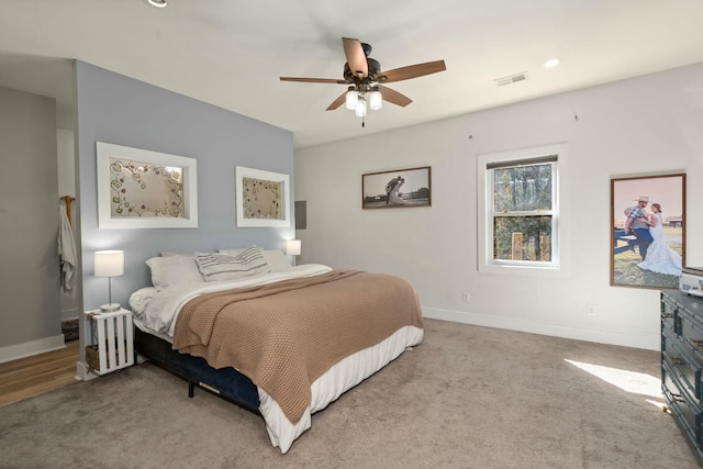 bedroom with baseboards, visible vents, ceiling fan, and light colored carpet