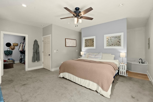 bedroom with baseboards, light colored carpet, a walk in closet, a closet, and recessed lighting