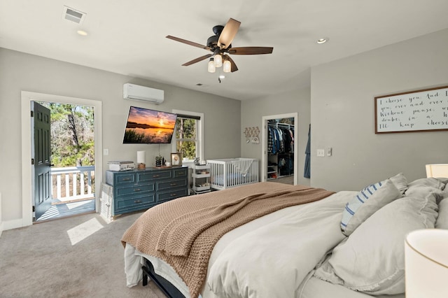 bedroom with light carpet, an AC wall unit, multiple windows, and access to exterior