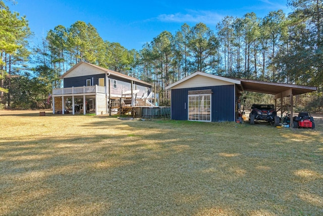 back of house with a carport, a lawn, and driveway