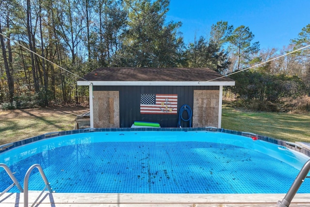 pool featuring a lawn and an outbuilding