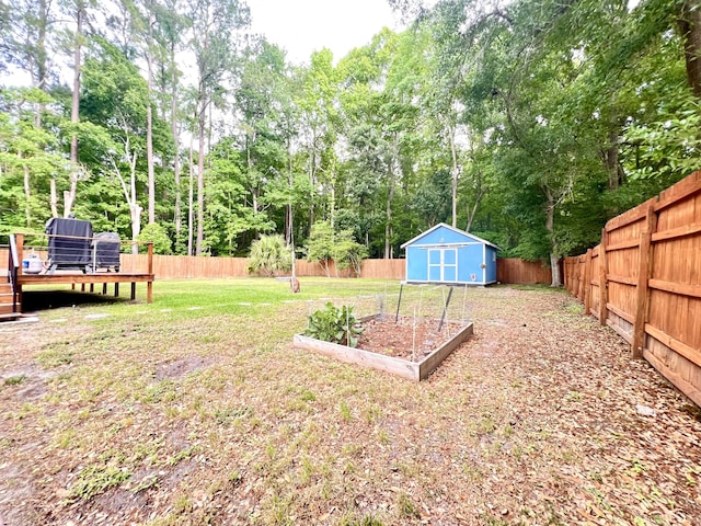 1325 Edward Dr, Moncks Corner, SC 29461 - view of yard featuring a storage unit, a deck, an outdoor structure, view of scattered trees, and a vegetable garden