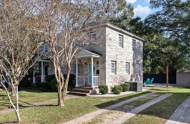 view of front of property featuring central air condition unit and a front yard