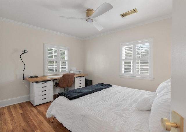 bedroom with ceiling fan, ornamental molding, and light hardwood / wood-style flooring