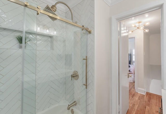 bathroom featuring hardwood / wood-style floors, tiled shower / bath, and crown molding