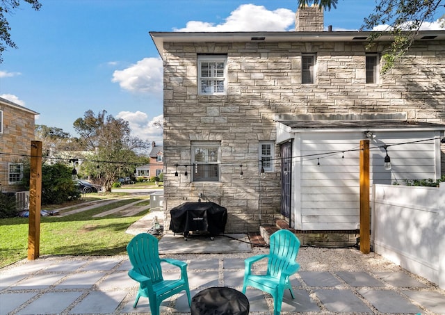 rear view of property featuring a lawn and a patio area