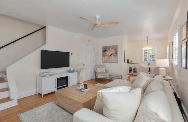 living room with ceiling fan, light wood-type flooring, and ornamental molding