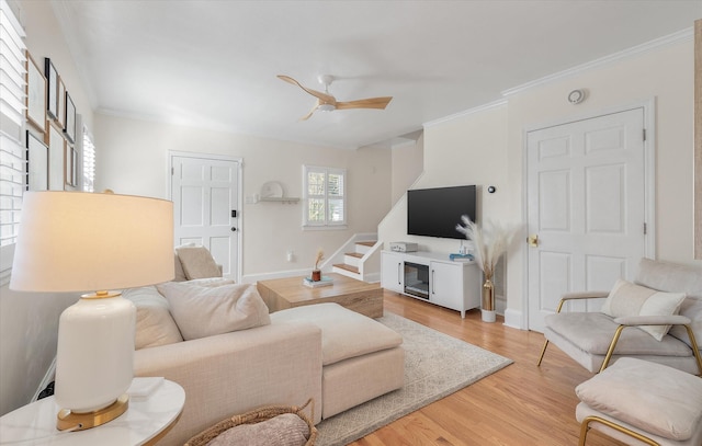 living room featuring hardwood / wood-style flooring, ceiling fan, and crown molding