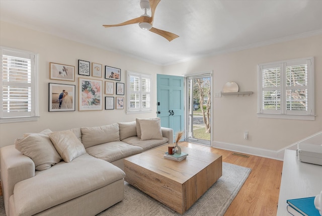 living room featuring light hardwood / wood-style flooring, ceiling fan, and ornamental molding