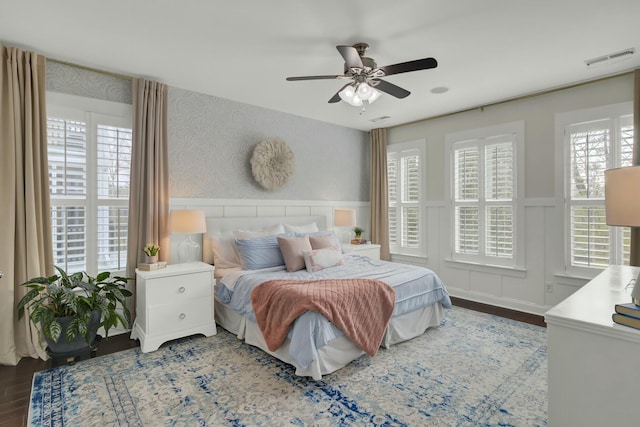 bedroom with multiple windows, hardwood / wood-style flooring, and ceiling fan