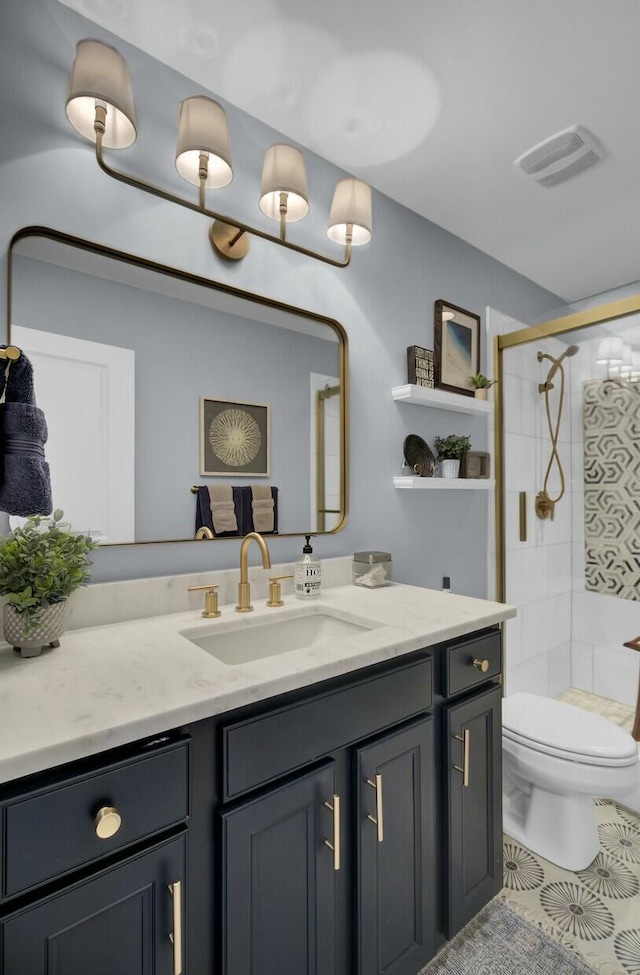 bathroom featuring tile patterned floors, vanity, toilet, and a shower with door