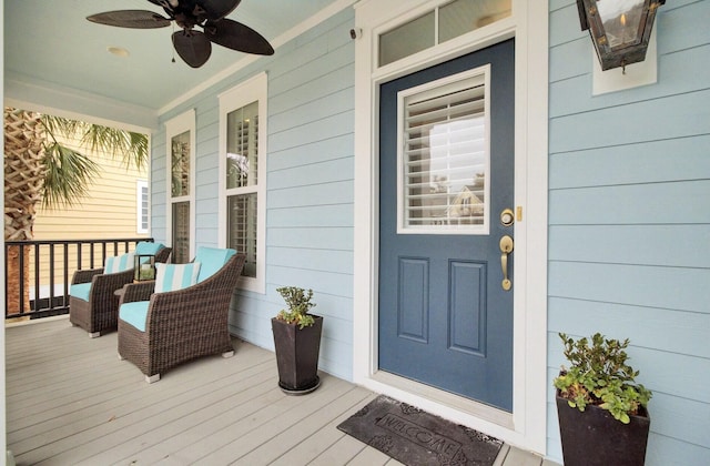 entrance to property with ceiling fan and a porch