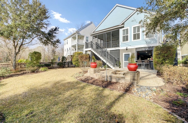 back of property featuring a sunroom, a lawn, ceiling fan, and a patio area