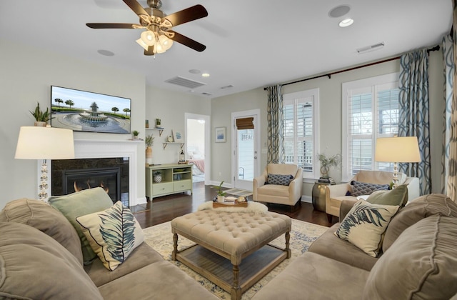 living room featuring a fireplace, dark hardwood / wood-style floors, and ceiling fan