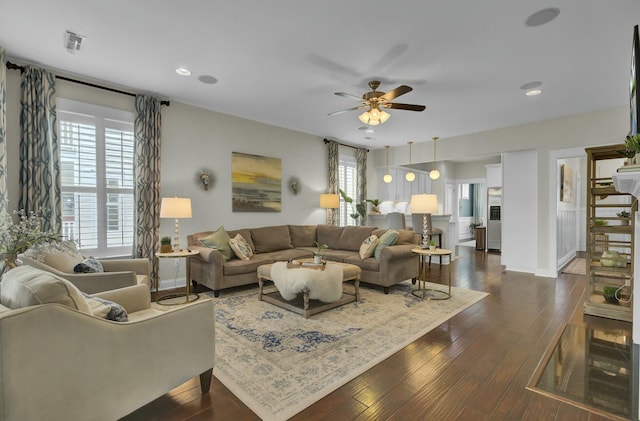 living room featuring ceiling fan and dark hardwood / wood-style flooring