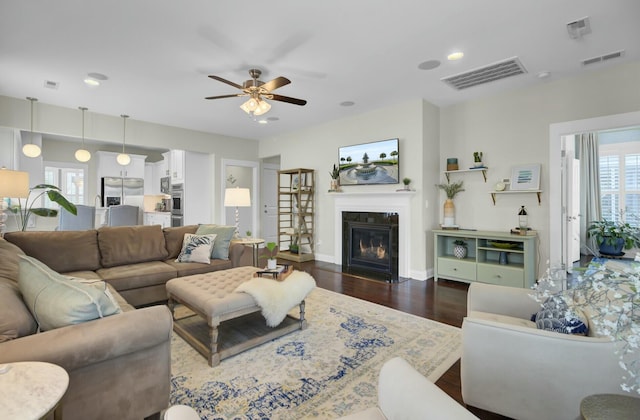 living room featuring dark wood-type flooring and ceiling fan