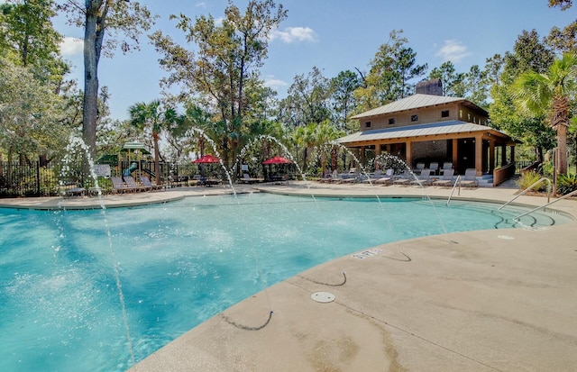 view of swimming pool featuring pool water feature and a playground