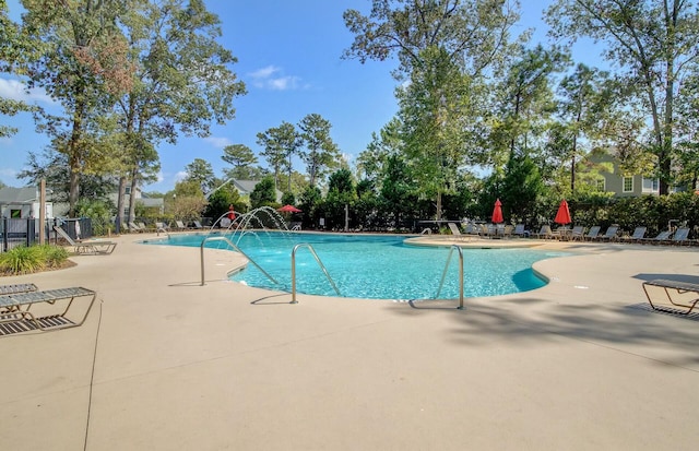 view of swimming pool with pool water feature and a patio