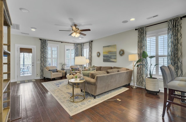 living room with dark hardwood / wood-style flooring and ceiling fan