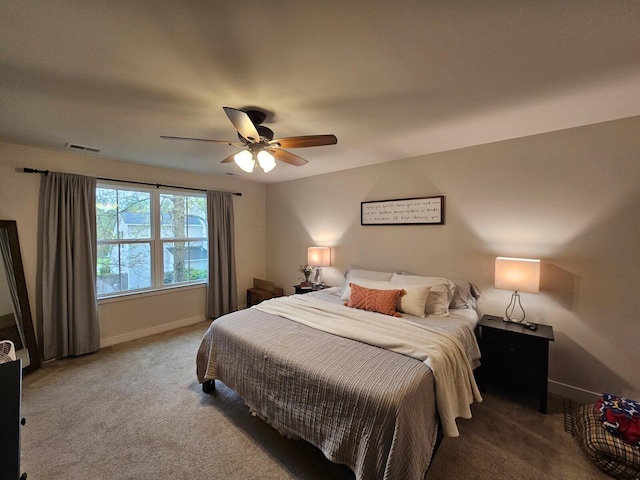 carpeted bedroom featuring a ceiling fan, visible vents, and baseboards