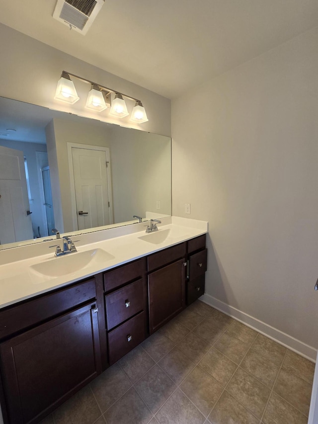 full bath featuring double vanity, baseboards, visible vents, and a sink