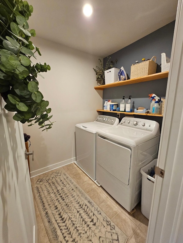 washroom with laundry area, washer and clothes dryer, tile patterned floors, and baseboards