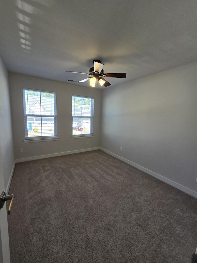 unfurnished room with a ceiling fan, carpet flooring, visible vents, and baseboards